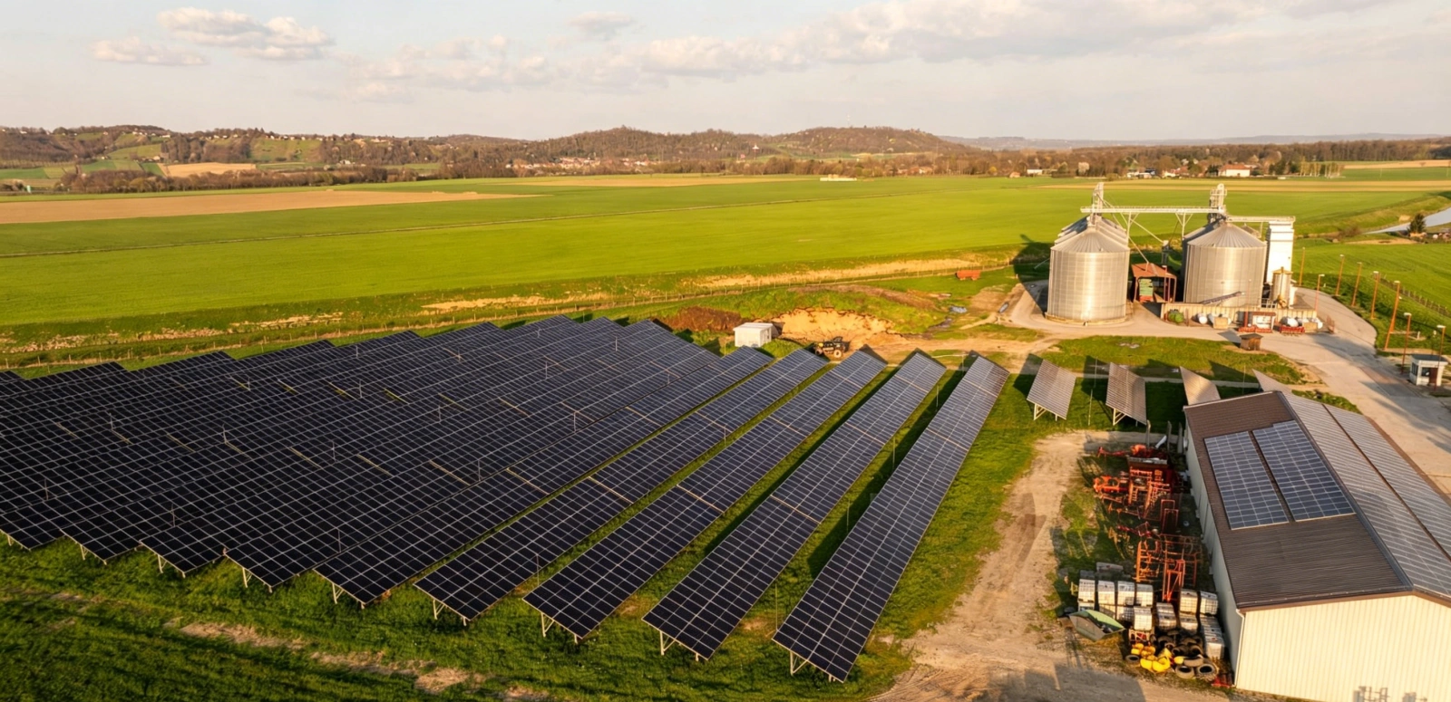An aerial view of an expansive solar array on an Argentine farm with storage silos and fields.