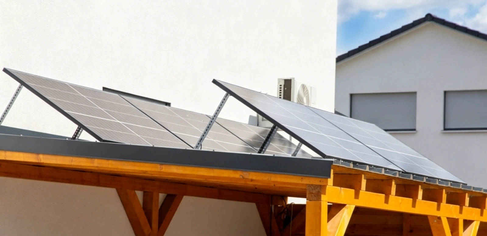 High-efficiency solar panels installed on a wooden carport structure next to a modern building.